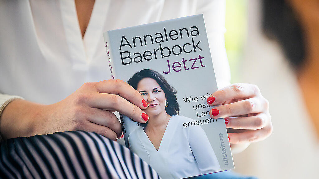 Baerbock hält ein Exemplar ihres Buches in Händen