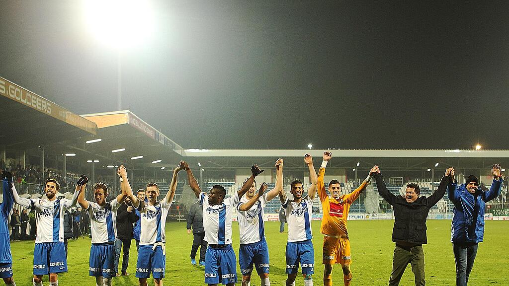 Mannschaft und Trainerteam des SV Grödig lassen sich nach dem 3:1-Erfolg über Rapid feiern.