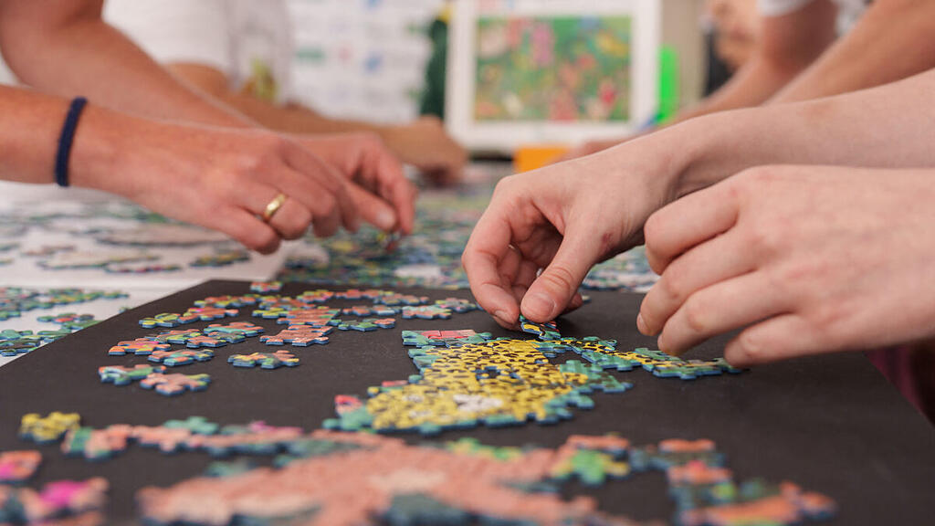 Nach dem gemeinsamen Puzzeln bewegen sich zwei Personen synchron