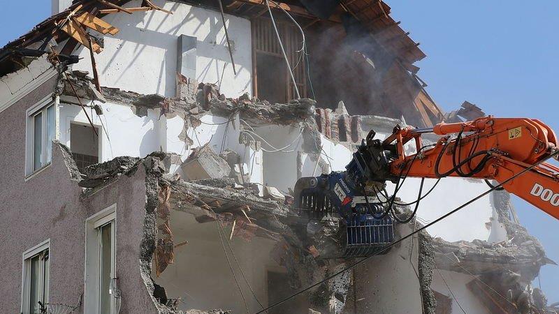 Bagger frisst sich durch Wohnblock