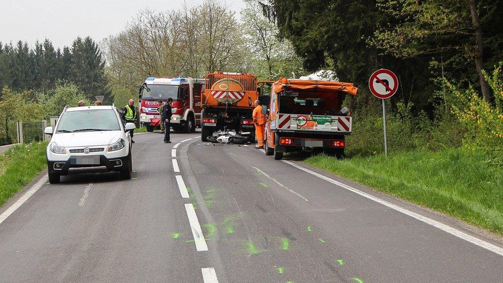 Biker schlittert unter Lkw