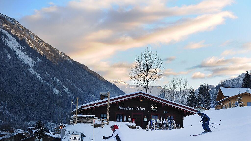 Zwei Skifahrer vor einer Skihütte im Skiort Flachau.