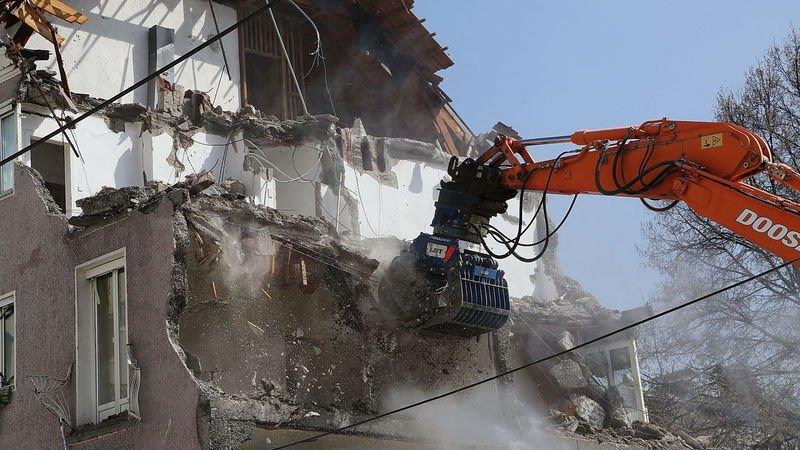Bagger frisst sich durch Wohnblock