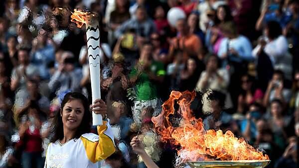 Griechische Ruderin Katerina Nikolaidou mit der olympischen Fackel