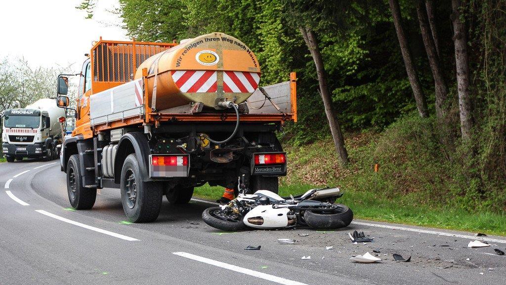 Biker schlittert unter Lkw