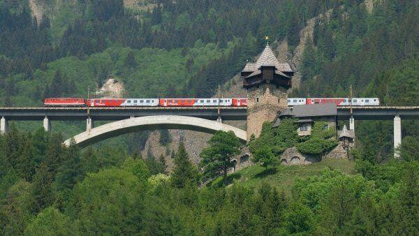 Ein Zug der Tauernbahn passiert Burg Falkenstein