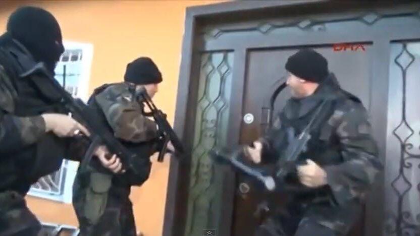 Die Polizisten mühen sich vergeblich an der Tür ab.