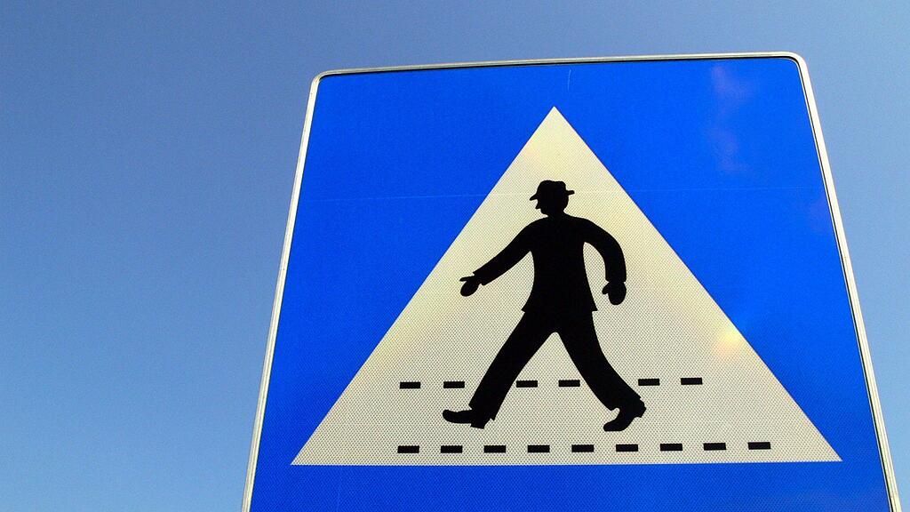 Die Frau überquerte die Straße ohne auf den Verkehr zu achten.