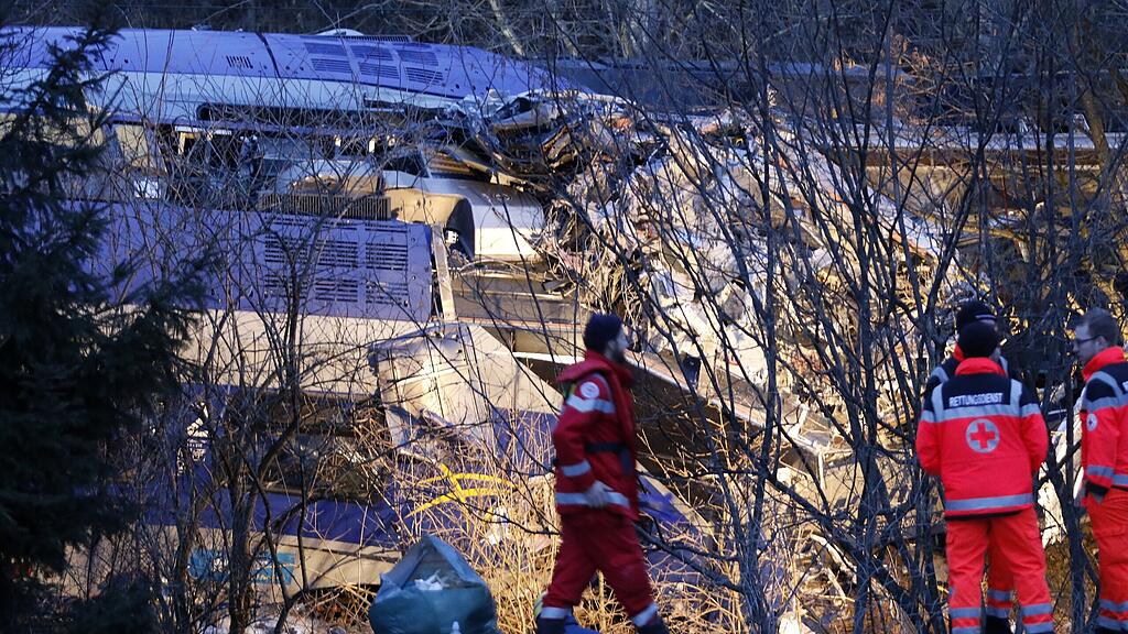Rettungskräfte stehen am Dienstagabend vor den Trümmern des Unglücks.