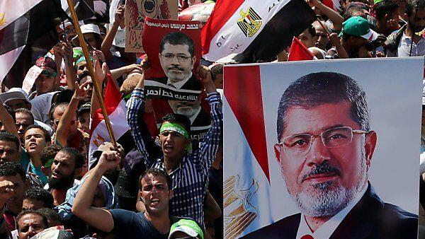 Muslimbrüder mit Plakaten von Ex-Präsident Mursi