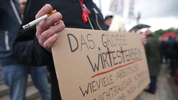 Demonstrant mit Zigarette und Taferl vor dem Parlament