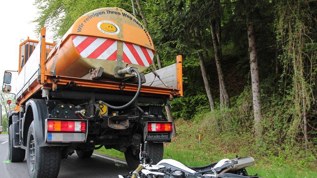 Biker schlittert unter Lkw