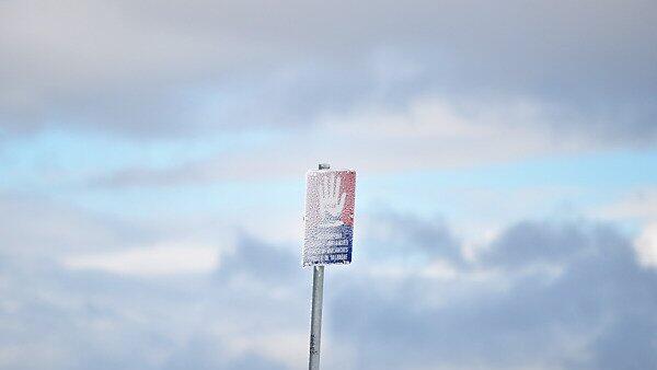 Lawinenwarnschild zwischen Wolken