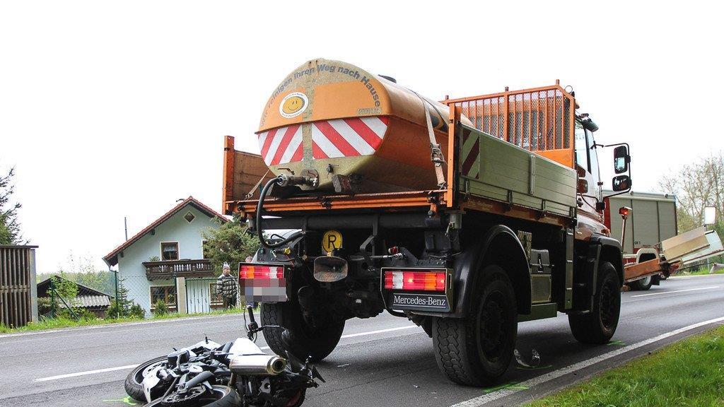 Biker schlittert unter Lkw