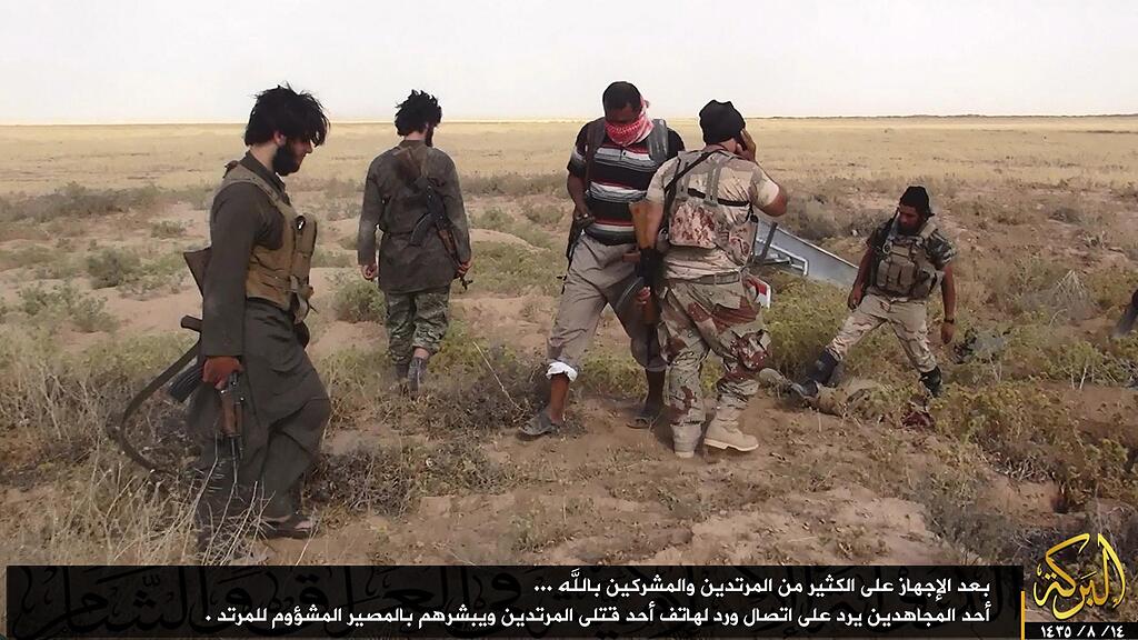 epa04262848 A photograph made available on 17 June 2014 by the jihadist affiliated group Albaraka News via their twitter account allegedly to show an fighters from the Islamic State of Iraq and the Levant (ISIL) taking position at an undisclosed location near the border between Syria and Iraq, 12 June 2014.  EPA/ALBARAKA NEWS/HANDOUT BEST QUALITY AVAILABLE. EPA IS USING AN IMAGE FROM AN ALTERNATIVE SOURCE AND CANNOT PROVIDE CONFIRMATION OF CONTENT, AUTHENTICITY, PLACE, DATE AND SOURCE. HANDOUT E
