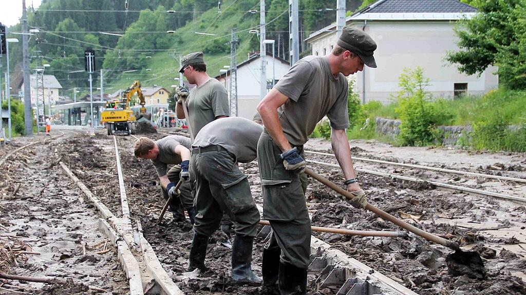 Nur mit Handarbeit können die Weichen im Bahnhof Taxenbach durch die Salzburger Pioniere vom Schlamm befreit werden.