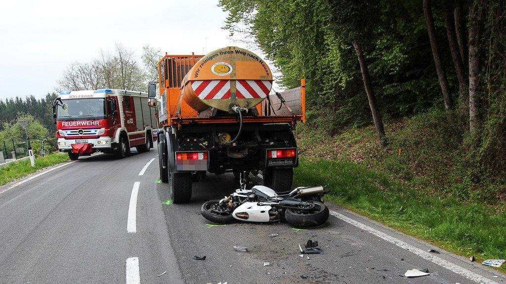 Biker schlittert unter Lkw