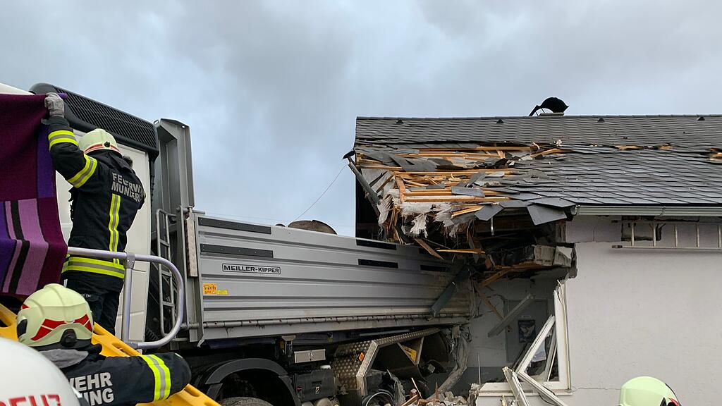 Lkw donnert in Hauswand und Zug