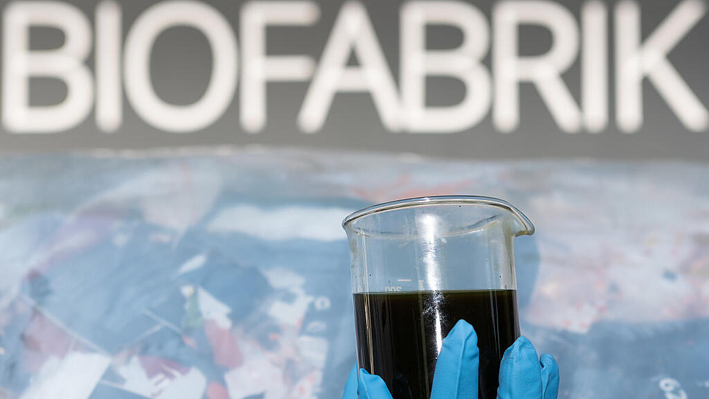 Ein Glas mit aus Plastik wiederverwerteten Öl