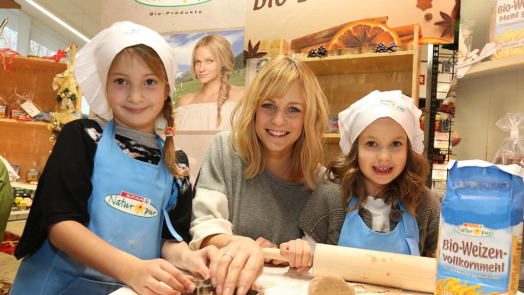 Mirjam Weichselbraun in der Weihnachtsbackstube mit Leoni und Cleo.