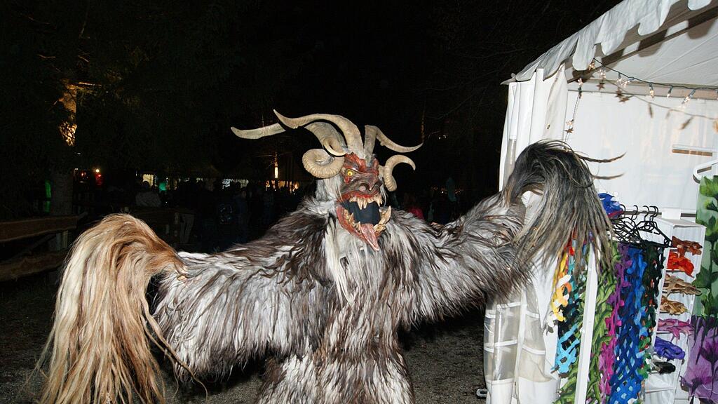 Die Altgnigler Krampusse und die Juvavum Pass eröffneten am Freitag Den Waldklang Weihnachtsmarkt in Anif.