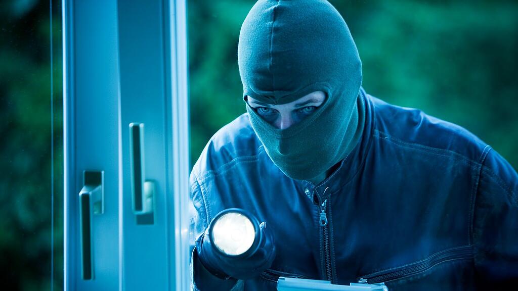 Der Einbrecher stieg über das ebenerdige Fenster in der Restaurant ein.