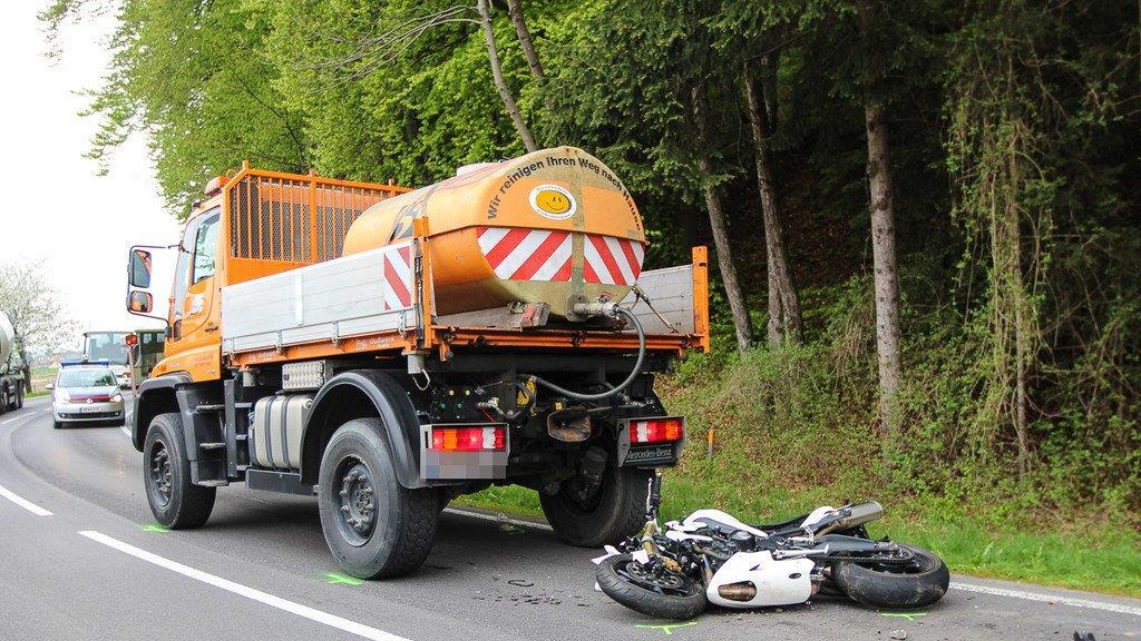 Biker schlittert unter Lkw