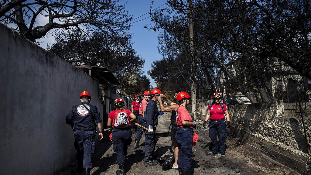 Feuerwehrleute gehen in Athen von Haus zu Haus und suchen nach Überlebenden.