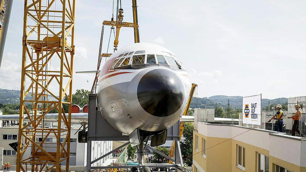 Das ausrangierte Flugzeug wird mit mehreren Kränen angehoben.